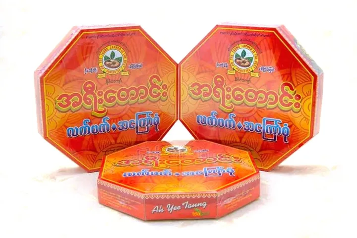 Three red octagonal Ah Yee Taung tins, printed with the shop's name in Burmese.